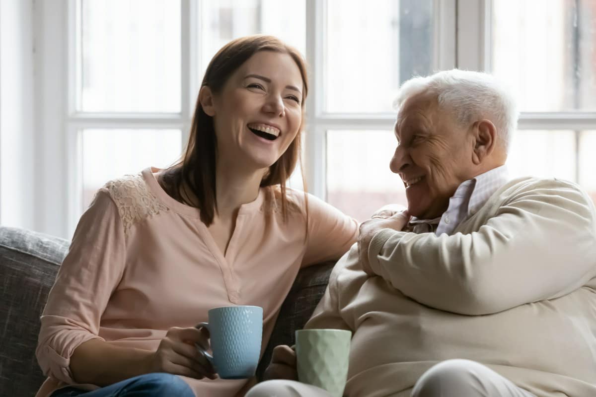 senior rozmawiający z młodszą kobietą na kanapie